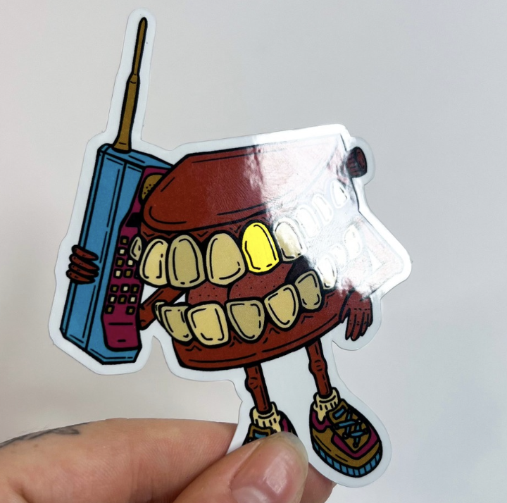 A brushed aluminum sticker of a cartoon character holding a phone