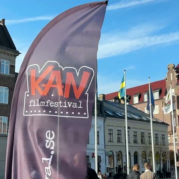 KAN Film Festivalin mainoslippu historiallisten rakennusten ja lippujen edessä aukiolla Lundissa